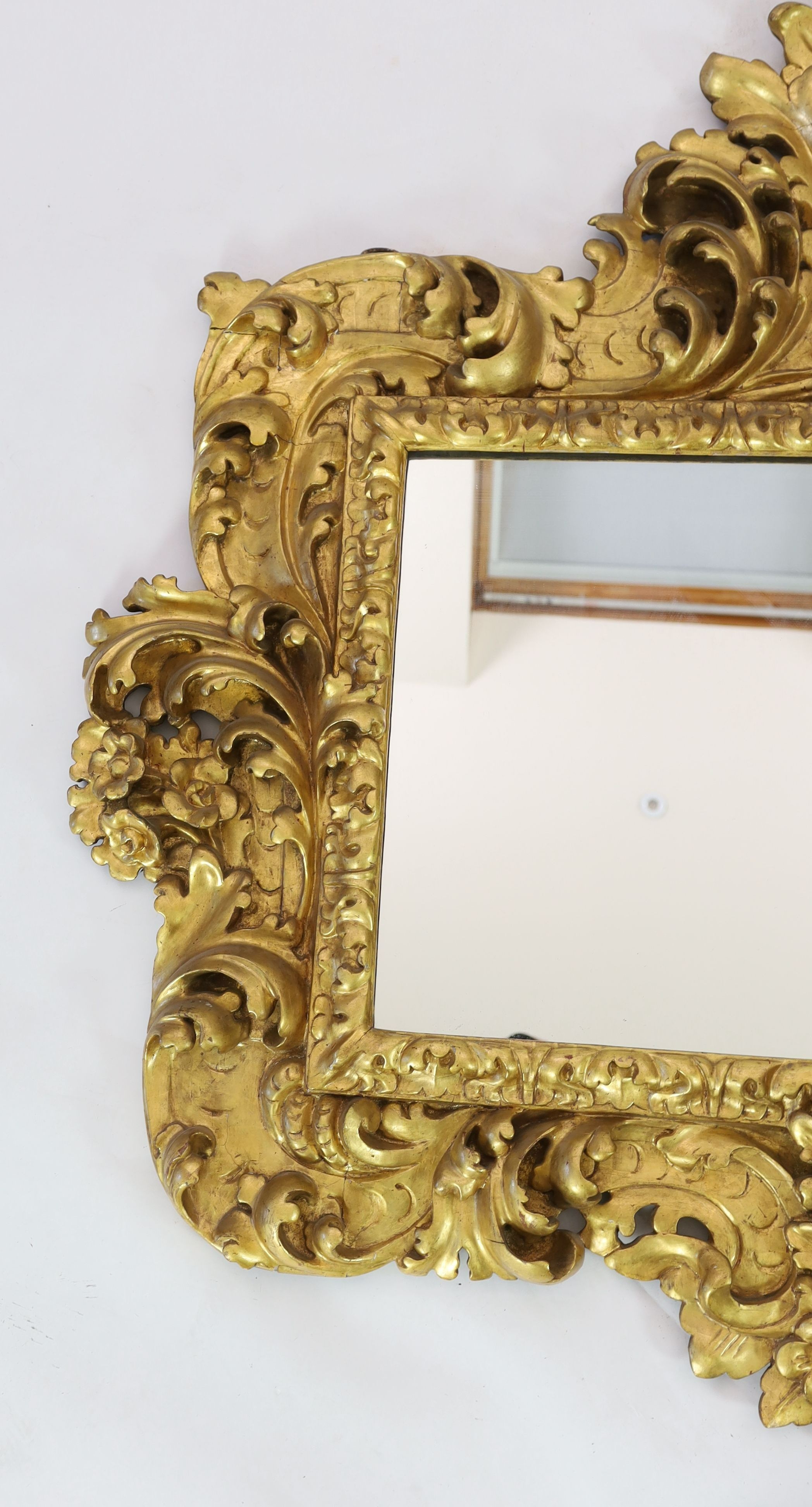 A mid 19th century Florentine ornately carved giltwood wall mirror, W.166cm H.158cm